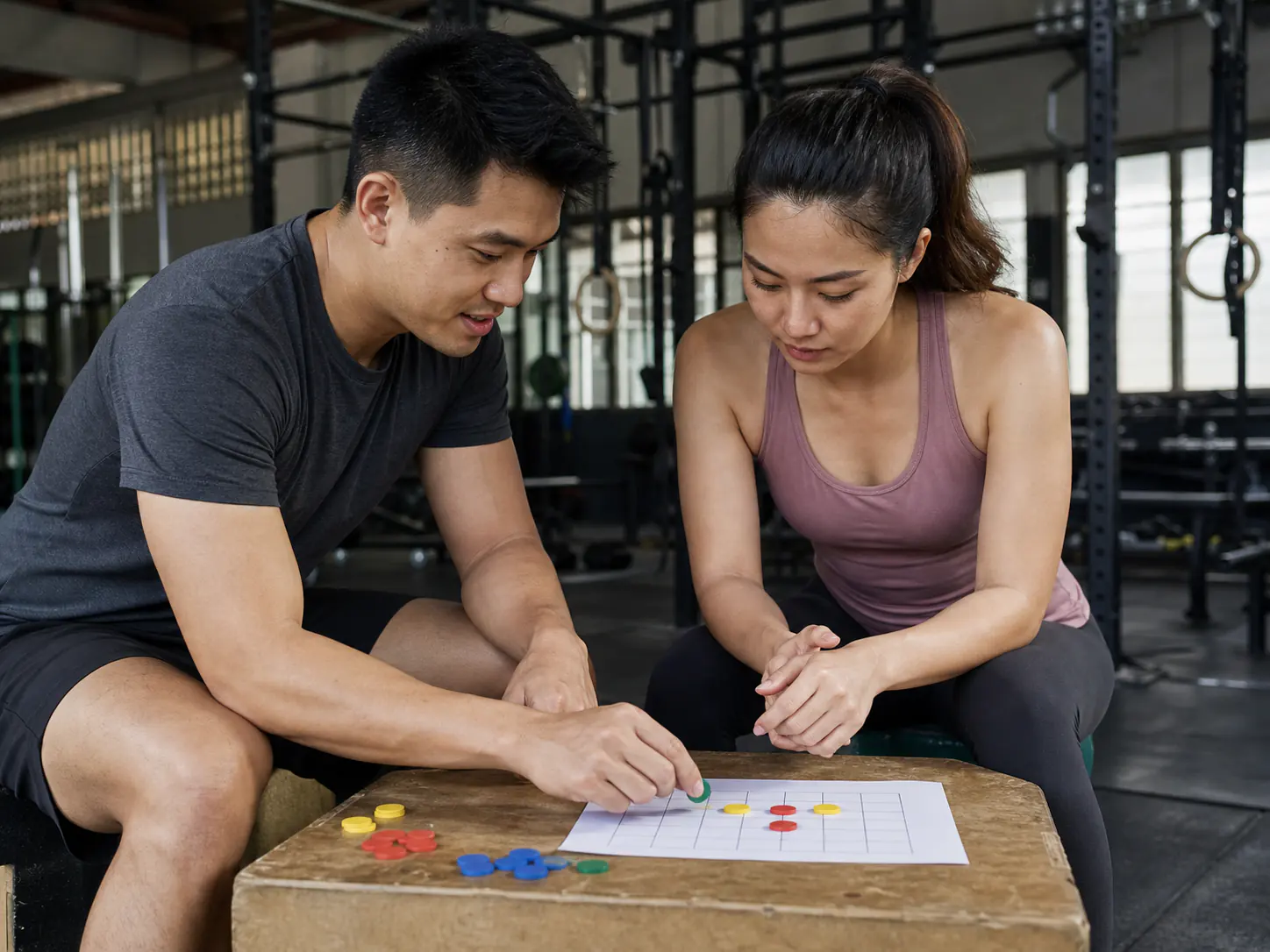 A trainer and client reviewing training progress between sets